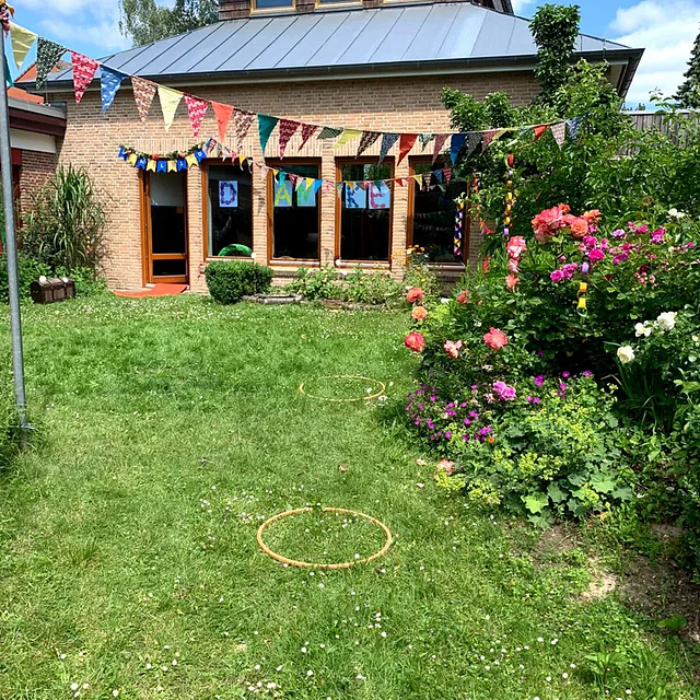 Festlich geschmückter Garten mit bunten Blumen und Wimpeln
