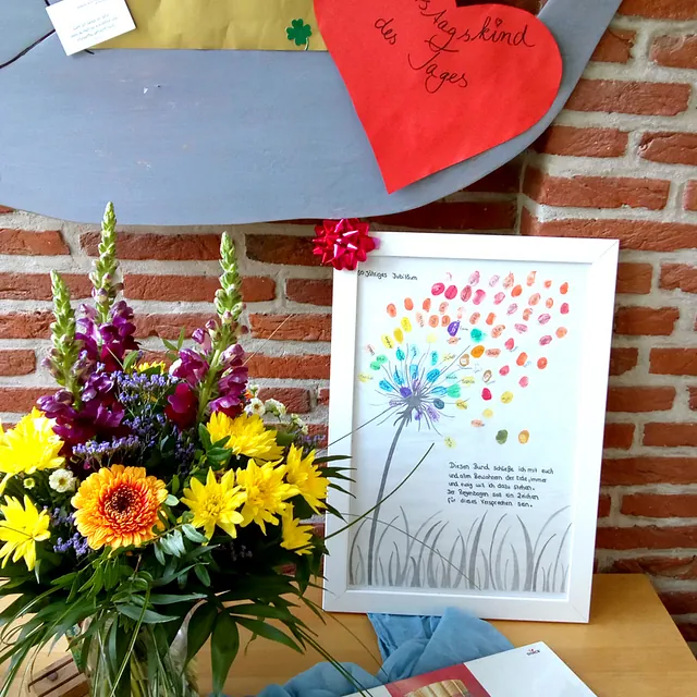 Blumenstrauß und Fingerabdruckbild auf Tisch