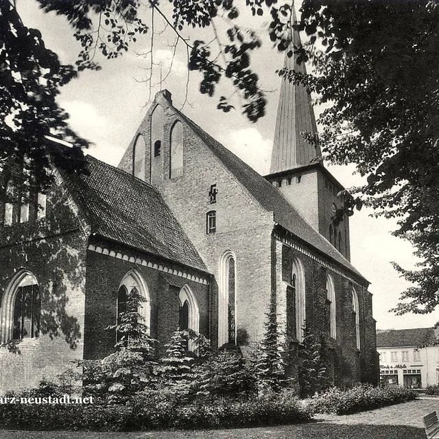 Seitliche Ansicht der Stadtkirche mit Bäumen.