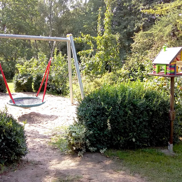 Spielplatz mit Nestschaukel im Grünen