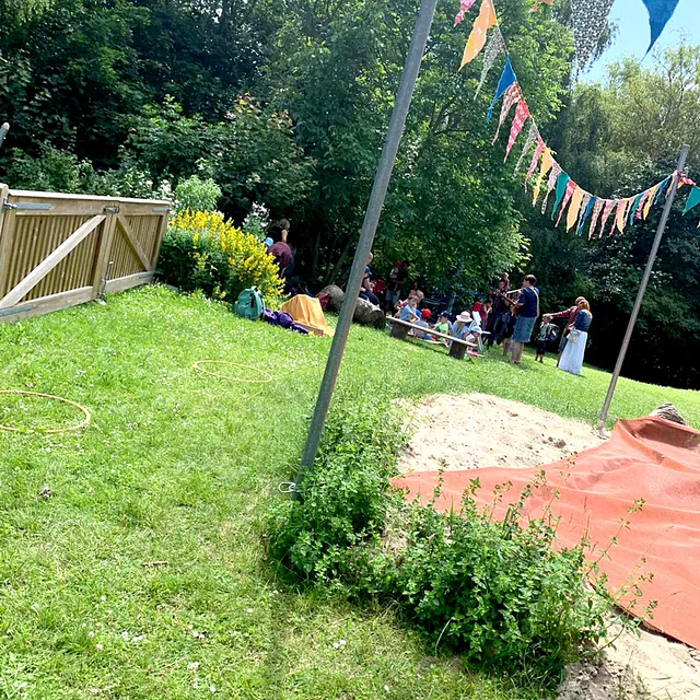Garten mit bunten Wimpeln und spielenden Kindern
